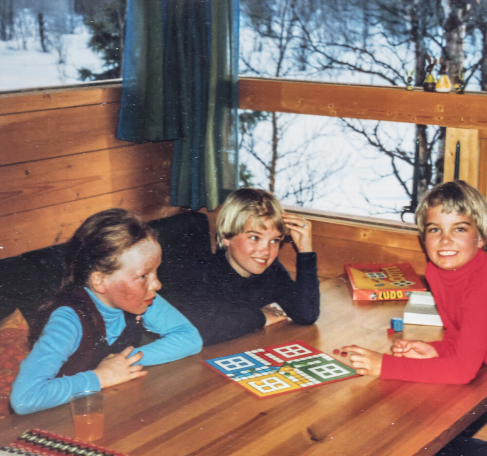 Turene til hytta var det beste med barndommen, synes Ellen. Her sammen med søsteren og kusinen. Ludobrettet brukes fortsatt. Foto: Privat