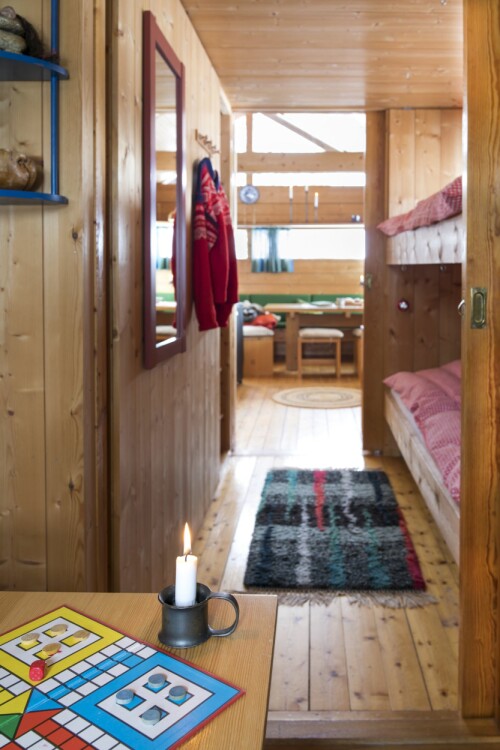 Lyset slippes tvers gjennom hytta på langs når skyvedørene åpnes. Det innerste soverommet er et tilbygg. Fra køyesengene kan man våkne til utsikten mot Reineskarvet.