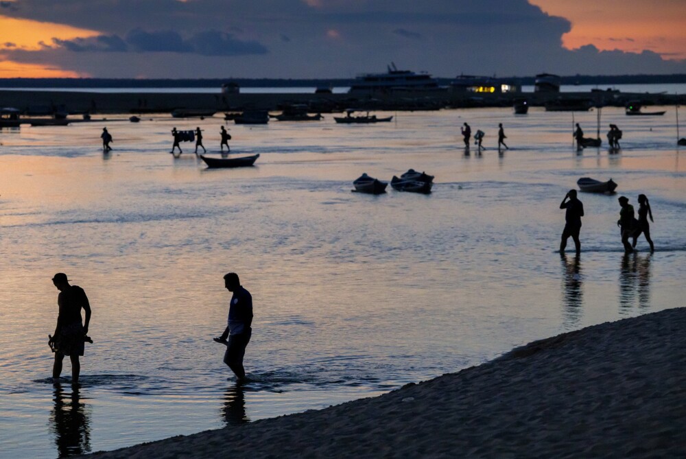 <b>SKUMRING:</b> Kvelden farger himmel og vann rosa, mens bade­gjestene vandrer tilbake til sine hoteller og noen fiskere kommer hjem fra en dag på elva.