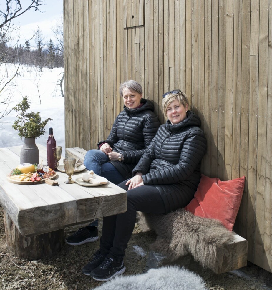 RESTER: Møblene på uteplassen har Steinar og kollegaene fått laget av restmaterialer, slik de også gjorde det på barndommens støl. Steinars kone Trine Andersen (til høyre) og venninnen Hege Fosheim koser seg i sola.