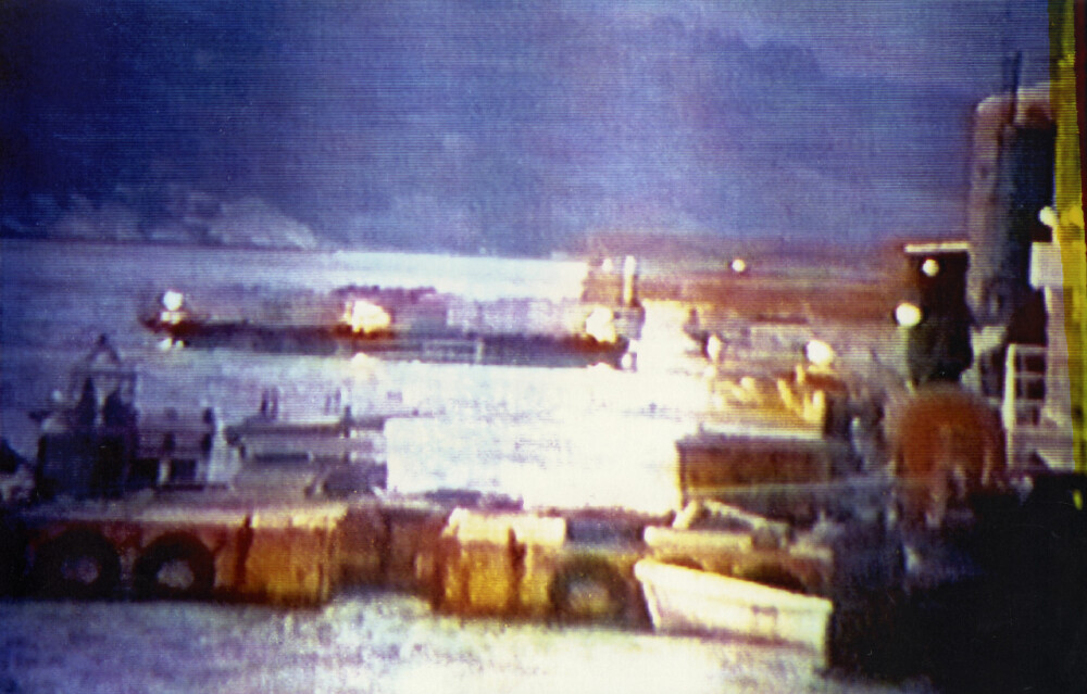 <b>LYSET GÅR:</b> Lanternene på toppen av søylene var det siste som forsvant i Gandsfjorden. Bildet er tatt fra en av slepe­båtene som brakte de 22 arbeiderne om bord i sikkerhet. 