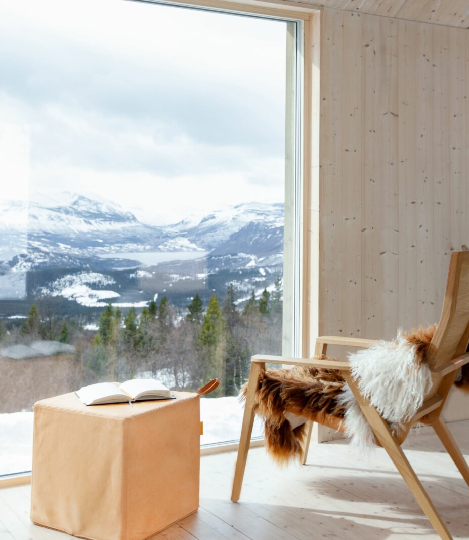 UTSIKT: Hytta er fylt med parets egendesignede møbler, som stolen og puffen laget for deres eget merke Thorsønn. Stolen flyttes til vinduet om dagen og tilbake til peisen om kvelden.