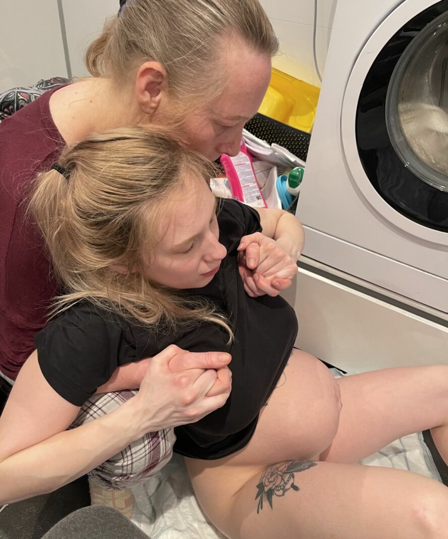 FØDSEL FORAN VASKEMASKINEN: Mamma Ida står bak og holder godt rundt datteren Anna som føder hjemme på badegulvet.