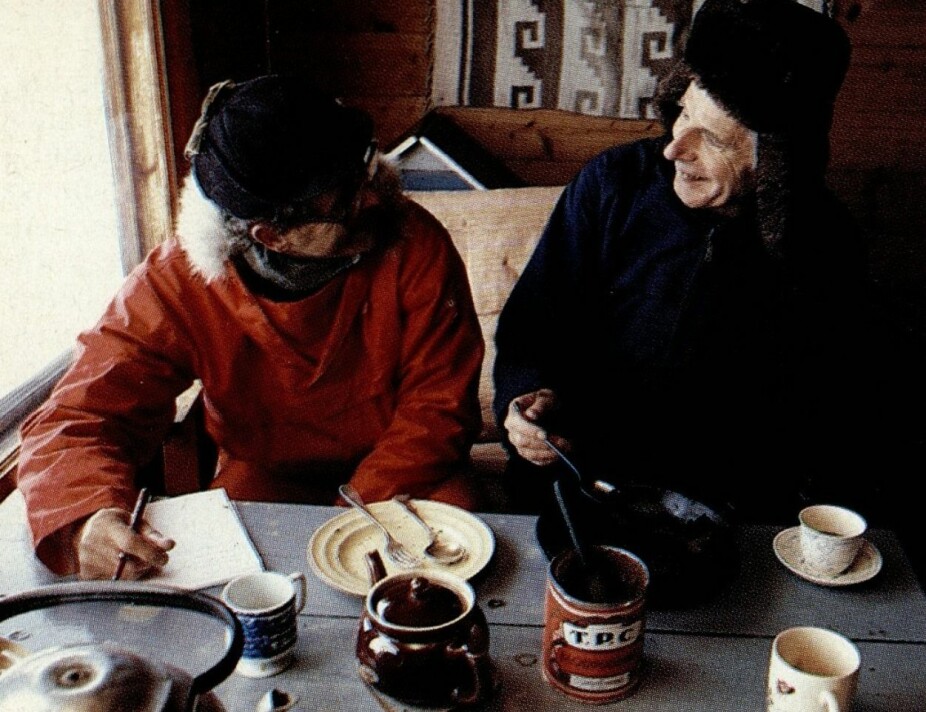 STUA PÅ TVERGASTEIN: Arne Næss (t.h.) i samtale med Hytteliv sin utsendte. På bordet står en boks av Næss' berømte blodpudding, et restlager som varte i flere tiår.