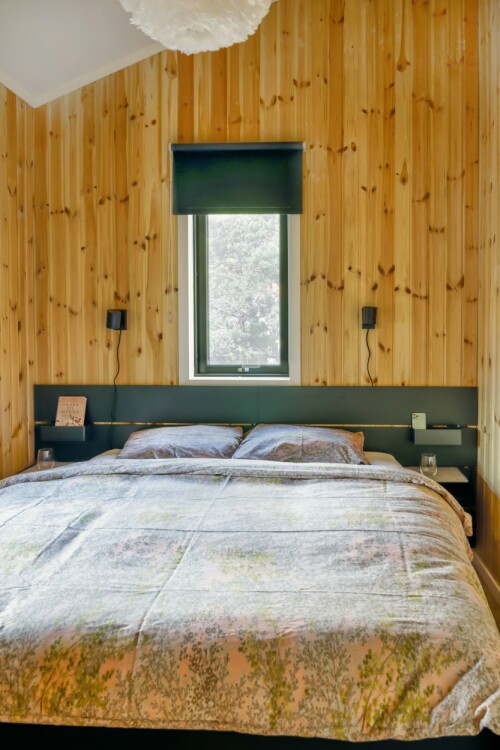 Lunheten trevirket gir, er grunnen til at veggene forblir umalte på soverommet. Selv om rommet er lite, er det godt å sove i, grunnet takhøyden. Sengegavl fra Ikea. Vindu fra Velux.