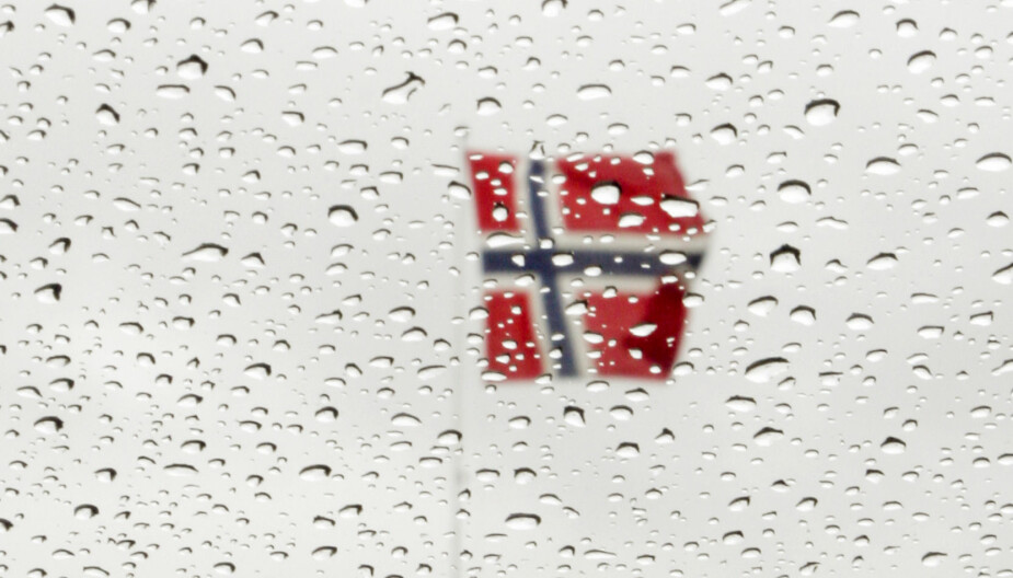 <b>GRÅTT OG VÅTT: </b>Et arkivbilde viser et flagg en regntung 17. mai. Det er store sjanser for at flere millioner nordmenn vil oppleve gråvær og noe nedbør på nasjonaldagen i år, melder Storm-meteorologen. Jo mer mot midten av Norge du bor, jo bedre vær kan du få. Foto: