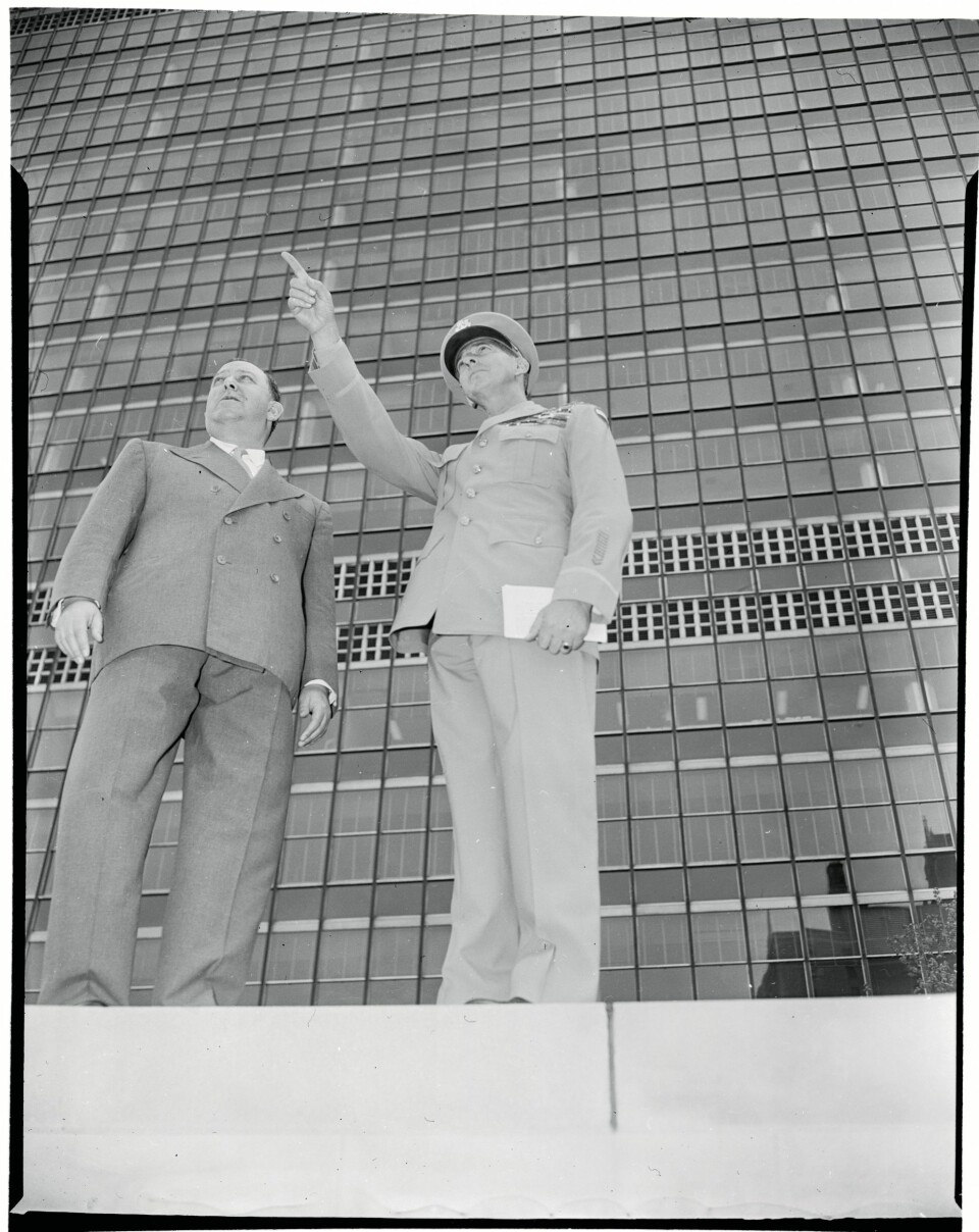 STOLTHETEN: FNs hovedkvarter i New York står igjen som den viktigste arven etter Trygve Lie. Her står nordmannen sammen med general Mark Clark foran den 39 etasjer høye, velkjente sekretariatsbygningen.