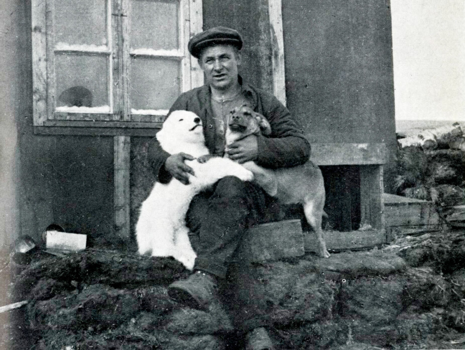 ISBJØRNKONGEN: Henry Rudi avbildet med en isbjørnunge og en hund på Svalbard. (Bil­det er hen­tet fra bo­ken «Henry Rudi, Isbjørnkongen).