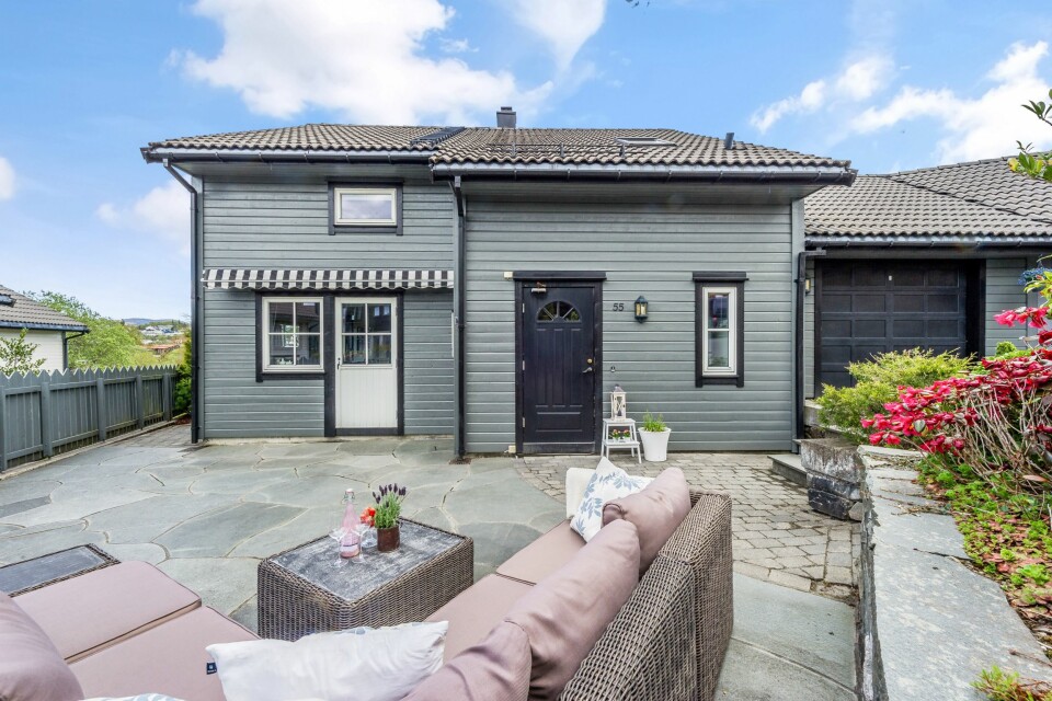 FØR: Forsiden av huset med stor steinplatting og belegningsstein.