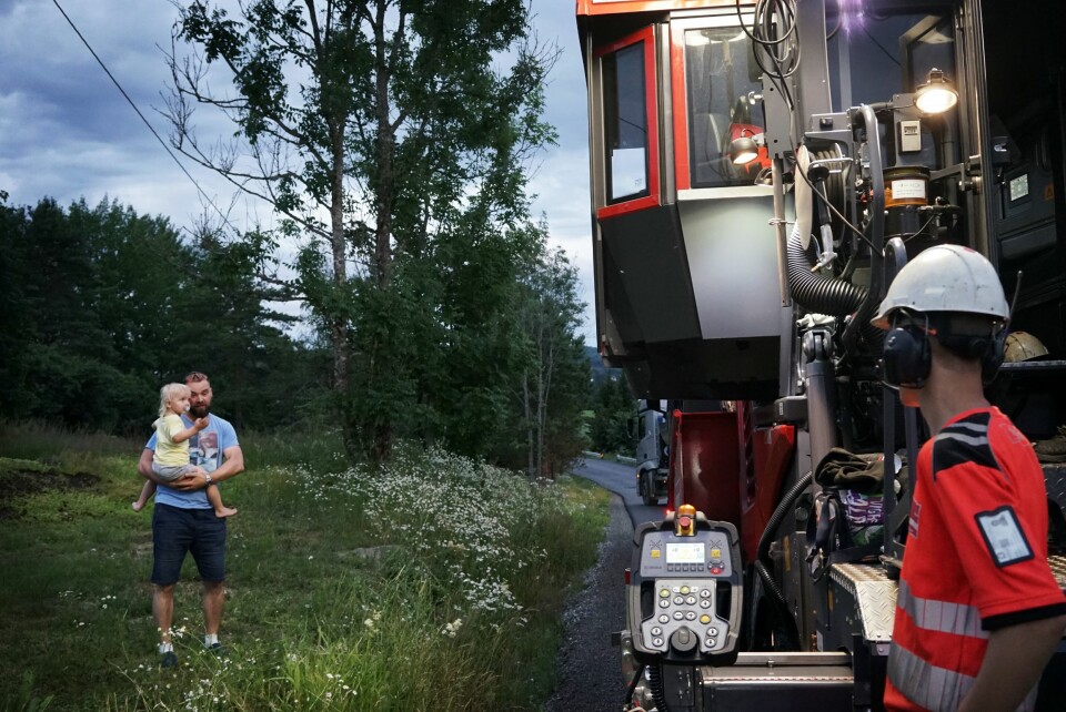 BRÅKER FÆLT: En henrykt Wiljar Gundersen på pappa Kristians arm studerer de store maskinene og arbeidet til Henrik Syversen. Er man 2,5 år, kan man ikke gå og legge seg før maskinene er sjekket ut.
