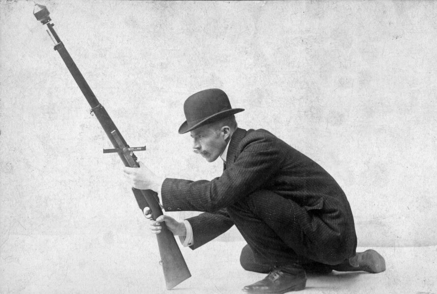 GRANATKONGEN: Nils Waltersen Aasen på et atelierbilde tatt i København. Aasen reklamerer for sitt produkt med følgende tekst: «Fotografiet viser min geværgranat klar til utskytning. Granaten går nesten dobbelt så langt, samt har 10 000 % større virkning, enn den nest beste geværgranat som finnes.»