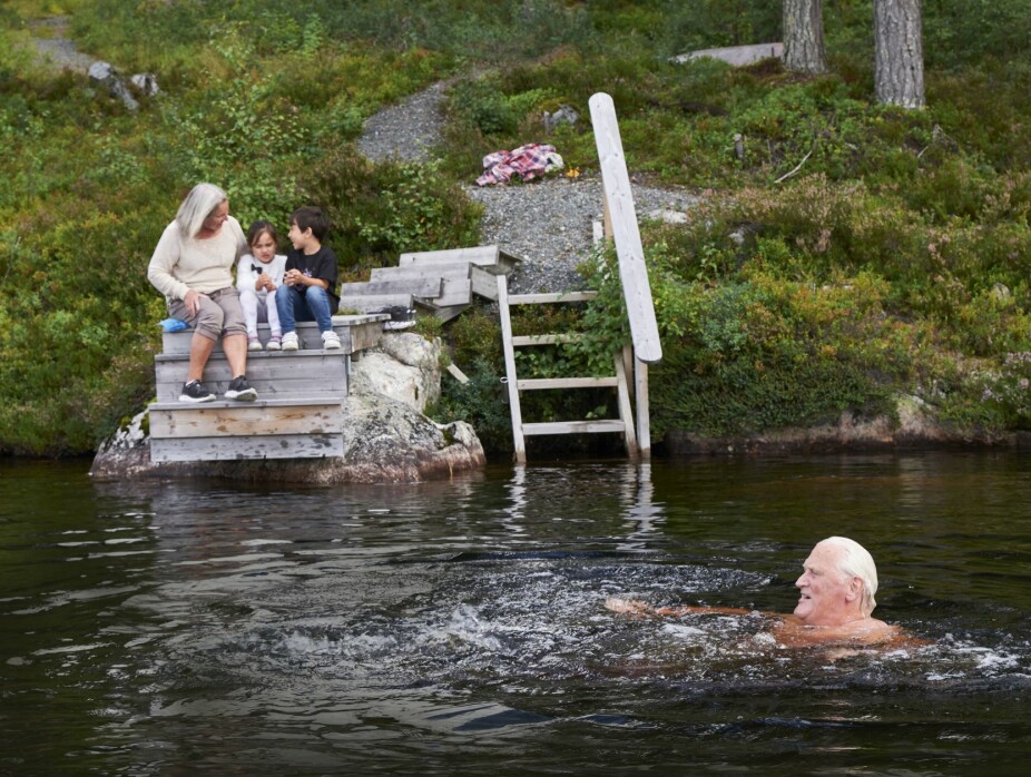 SES IGJEN NESTE SOMMER: Sommerens siste bad for Rolv i Grytevatn mens Berit og barnebarna Tia og Tim koser seg på land. I bakgrunnen ser vi tømmerhytta.