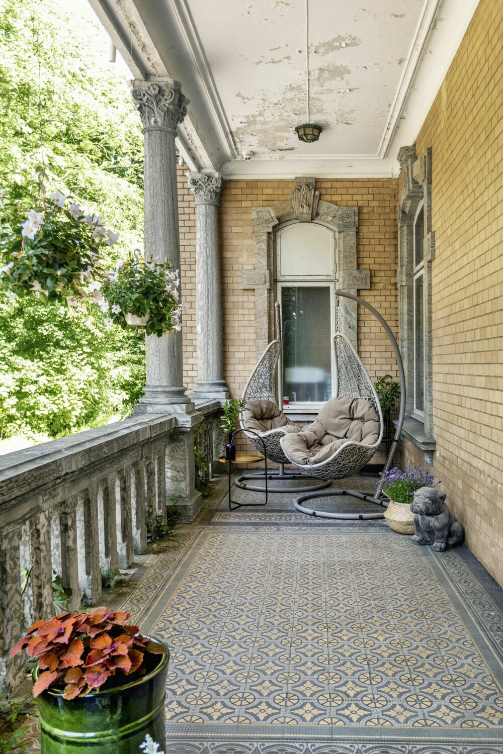 Stolene på terrassen i første etasje ble kjøpt på Bohus for noen år siden. I åpningen mot gårdsplassen henger to store ynder (Mandevilla).