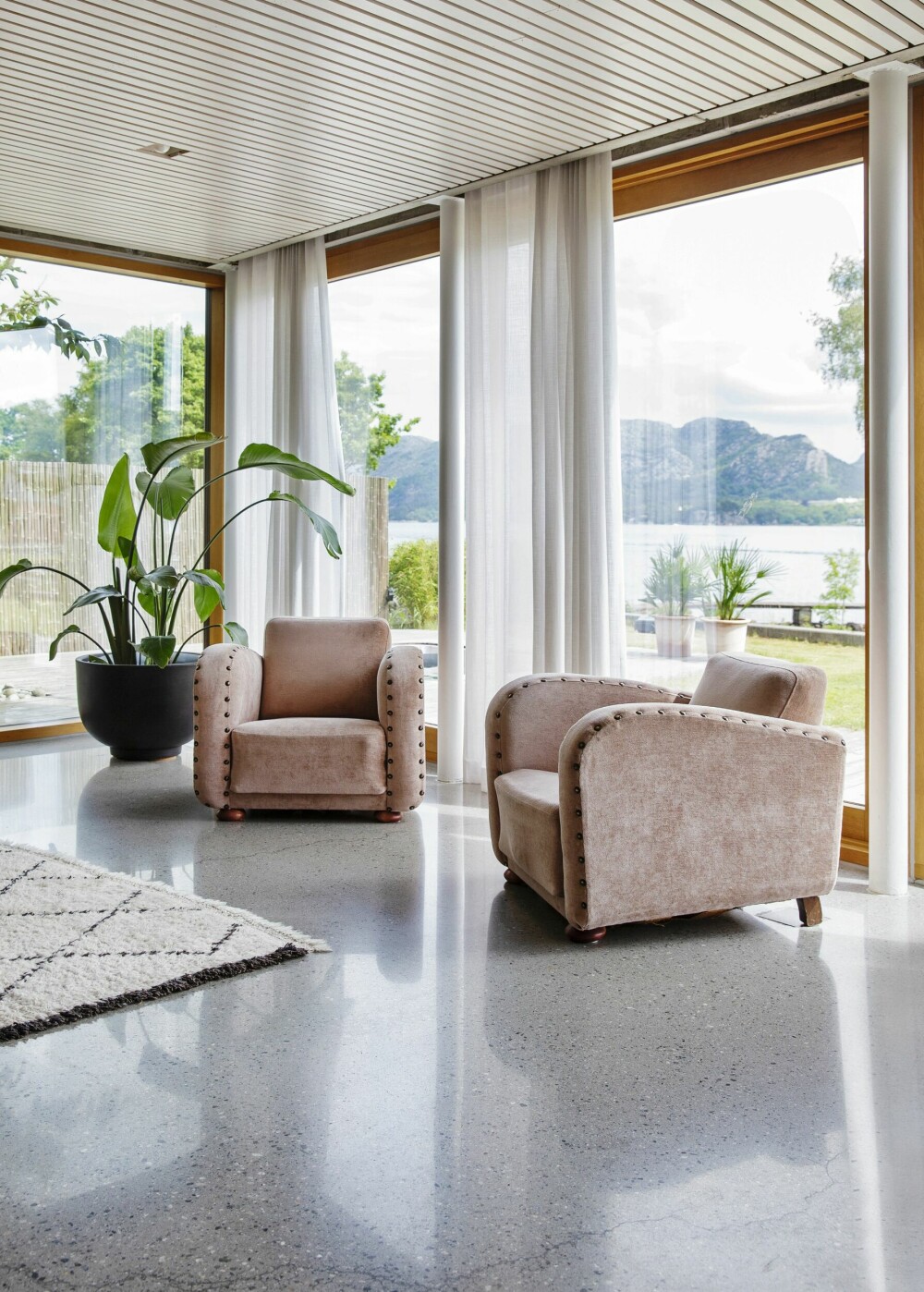Husets arkitektur gjør maksimalt ut av det vakre lyset langs Rogalandskysten. De rosa stolene er vintage og viser hvordan Ann Kristin liker å mikse ulike stiler.