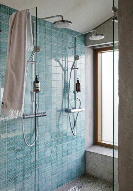 Den turkise fliseveggen på badet gir en energiboost for den som skal ta seg en dusj. Flisene er fra Made a Mano og dusjen fra FM Mattsson.