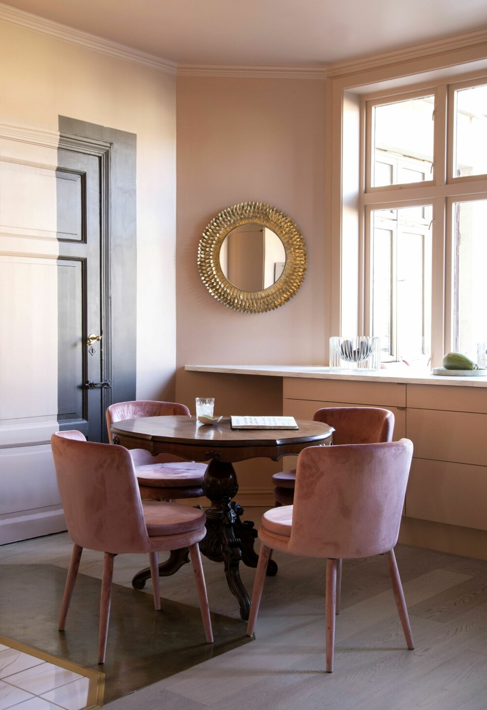 Spiseplassen på kjøkkenet består av et gammelt trebord og helrosa stoler fra Ellos. En del av døren ut mot baktrappen og et område av veggen er malt i fargen Tjærebrun. – Jeg kunne tenke meg et innslag av brunt sammen med det rosa, og jeg liker denne løsningen.
