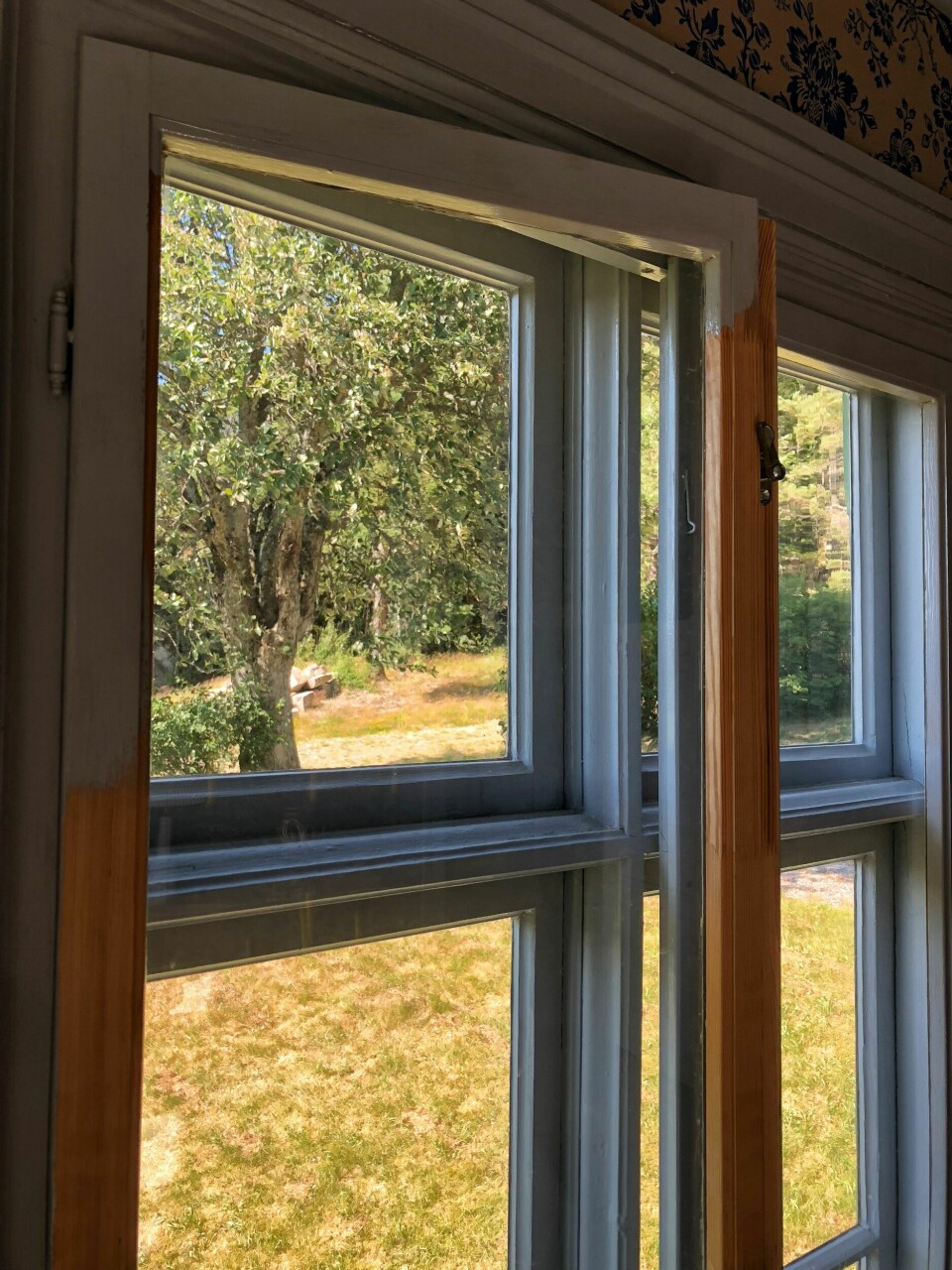 Her er det laget enkle innervinduer som ikke stjeler for mye oppmerksomhet fra yttervinduene. Og de er malt i samme farge som karm og yttervindu, nemlig en klassisk blålig gråfarge som er med på å slippe lyset inn i rommet.