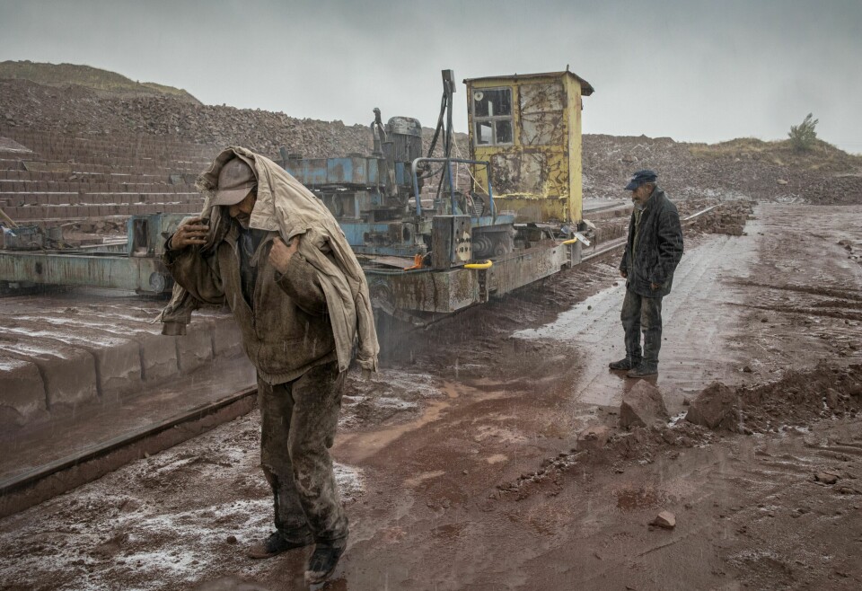 FORFRISKET PÅ JOBB: For en nordmann som er vant til arbeidsplasser med kaffemaskin, alt som finnes av verneutstyr, HMS-fokus og Akan-opplegg, er det kanskje forståelig at disse karene myker opp arbeidsdagen med en støyt vodka eller ti. Her holder Ruben og Seyran en av steinkutterne i gang, mens det regner og sludder om hverandre.