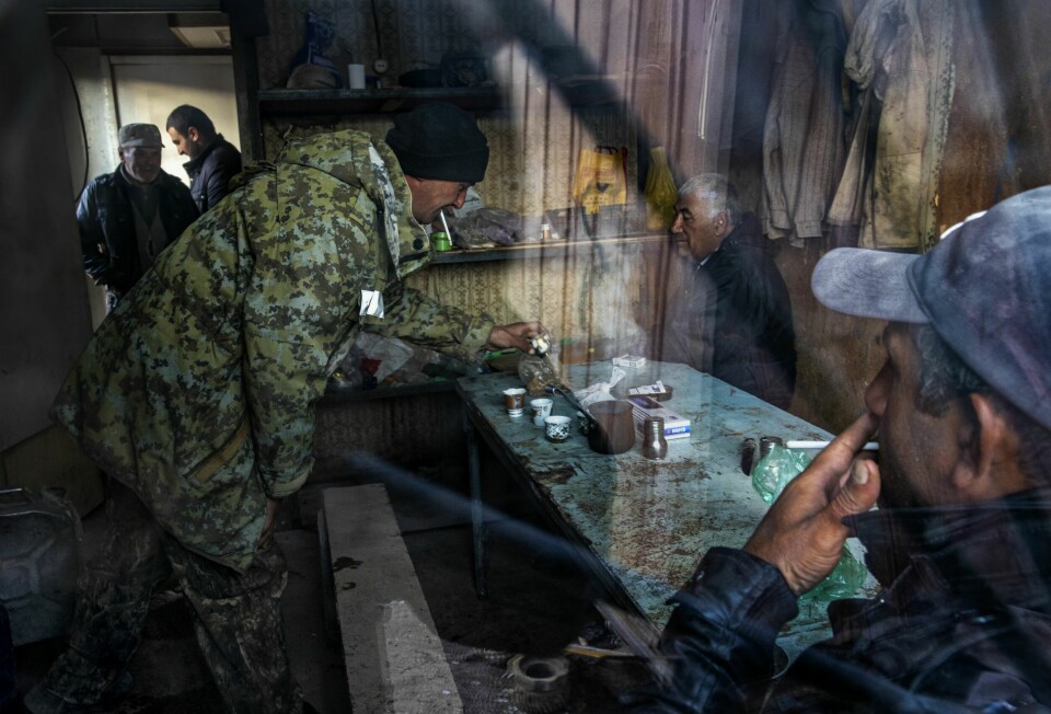 RØYKEROM: Av 28 arbeidere er det kun to som ikke røyker. Her tar noen av mennene en pause i varmebua.