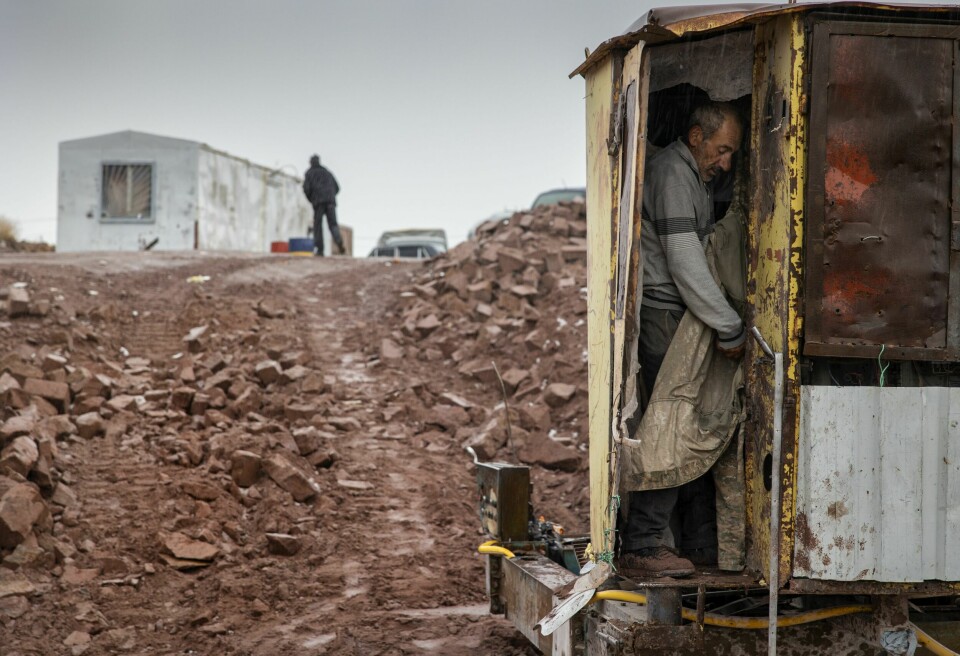 GARDEROBEMANNEN: Ruben skifter til tørr jakke inne i steinkuttermaskinene han og Seyran opererer. Dagen er over, og begge gutta er våte av regn og sludd.