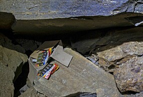 <b>SØPPEL:</b> Batterier og papp, samt noe klær, ligger under en stein ikke langt fra inngangen.