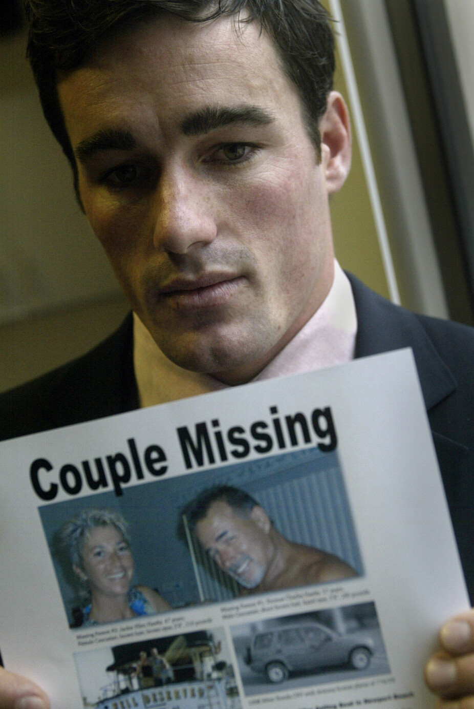 I SORG: Ryan Hawks holder opp en savnet-plakat etter at hans far Thomas Hawks og farens kone Jackie Hawks forsvant sporløst etter at de solgte båten sin. Bildet er tatt 8. desember, 2004.