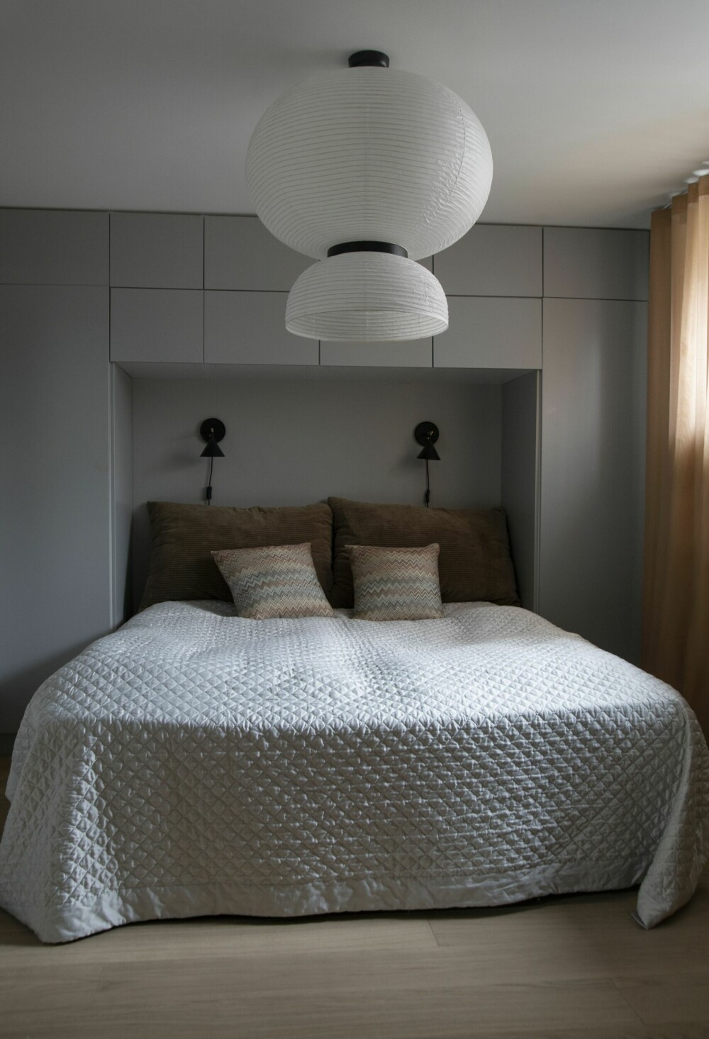 På soverommet er veggen rundt sengen utnyttet til oppbevaring med garderobeløsning fra Kvik. Sengetøyet er fra Høie, leselampene fra Menu og taklampen fra &amp;Tradition.