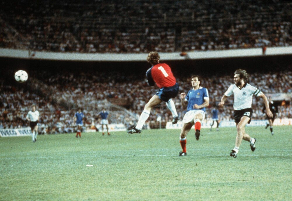 <b>INNKOMMENDE:</b> Ett ikonisk og smertefullt øyeblikk i VM-historien: Vest-Tysklands målvakt Toni Schumacher kvester Frankrikes Patrick Battiston i semifinalen i 1982. Det var kampen som hadde alt – unntatt en rettferdig vinner, i øynene til alle andre enn tyskerne. Manfred Kaltz til høyre. 