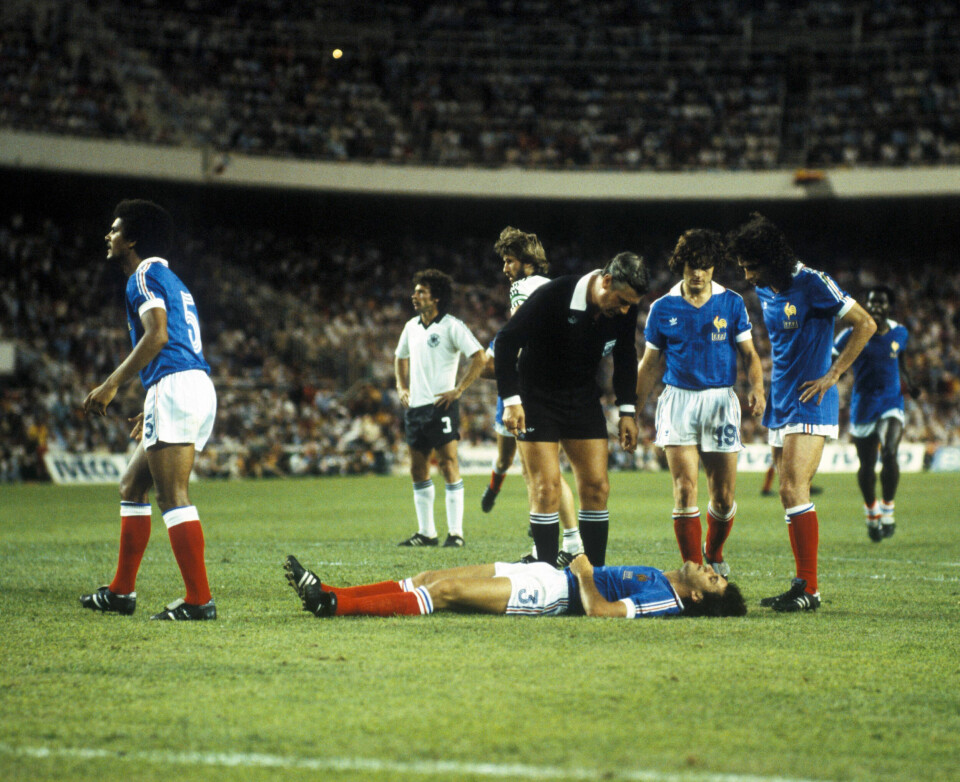 UTSLÅTT: Dommer Charles Corver fra Nederland fikk ikke med seg sammenstøtet, og dømte utspark fra mål. Gerard Janvion (til v.) ser etter hjelp, mens Didier Six (nr 19) og Dominique Rocheteau har samlet seg rundt sin utslåtte lagkamerat.