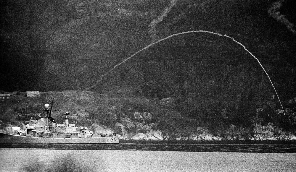 <b>SKARPT SVAR:</b> Fregatten KNM Oslo avfyrte røykrakett som signal til andre militære fartøyer som deltok i ubåtjakten i Hardanger. Ved sonarkontakt med den antatte ubåten ble skarpe raketter og dypvanns­bomber brukt. Bernt Harald Utne satt sentralt i operasjonsledelsen, mens norsk og internasjonal presse ryddet førstesidene til stoff om ubåtjakten.