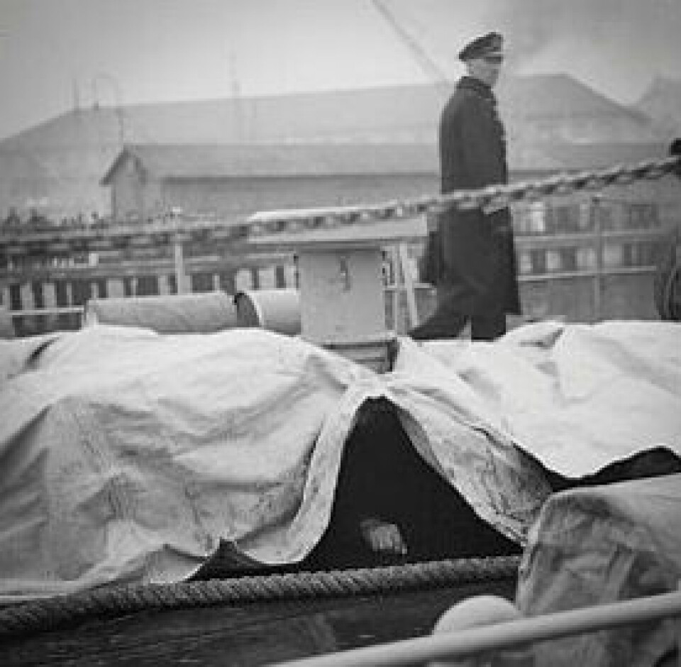 LIK: En hånd skimtes under presenningen der døde tyske soldater ble lagt.