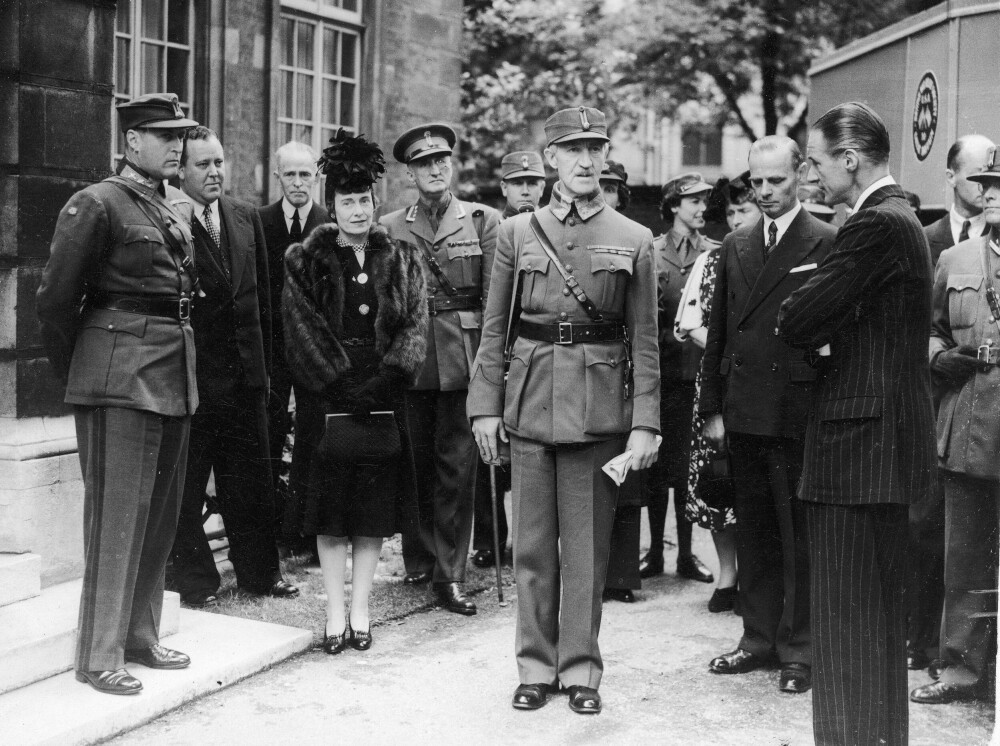 <b>STRAM GENERAL:</b> Viljestyrken og fastheten som ofte frem­heves som Fleischers fremste karakter­trekk, kan anes i dette bildet fra en sosial begivenhet i London. Kronprins Olav til venstre. Kvinnen på bildet er den amerikanske ambassadør­fruen.