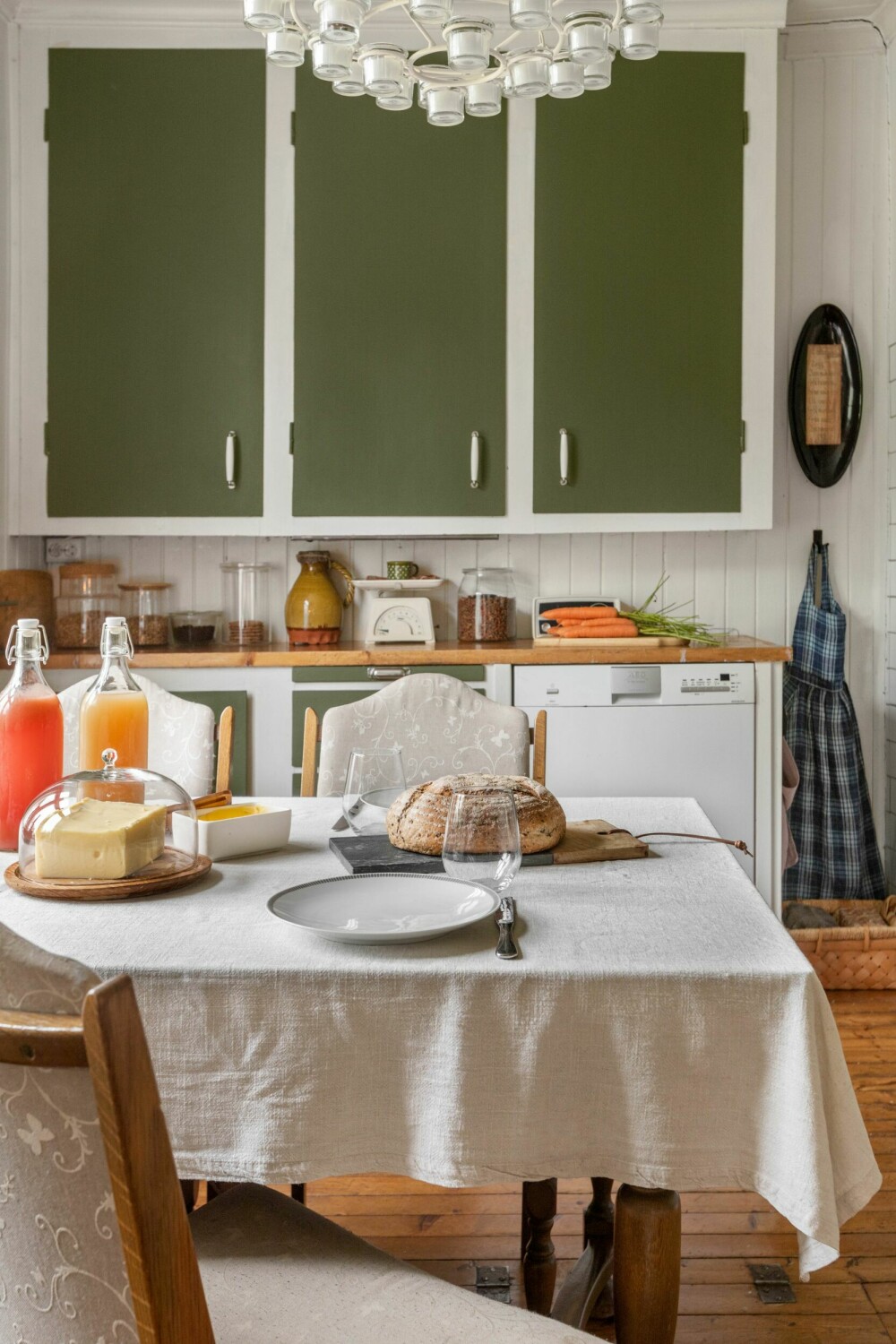 KJØKKEN: Skapdørene på kjøkkenet har hun malt i fargen Organic green. Bordet og stolene er arvegods.