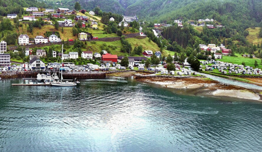 TRENGSEL: I høysesongen kan fort 8000 mennesker være i Geiranger i løpet av et døgn. Vitenskapsmannen uten alibi holdt til i én av de tre hyttene lengst til høyre i bildet bak campingplassen. Midt på bildet i bakgrunnen: Union Hotell der Trude jobbet.