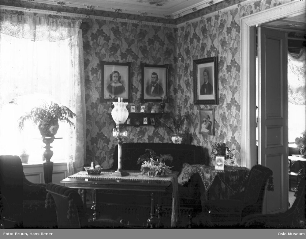 Et klassisk historisk interiør med ei enkel parafinlampe stående på bordet. Slike lamper har ofte blitt elektrifisert. 