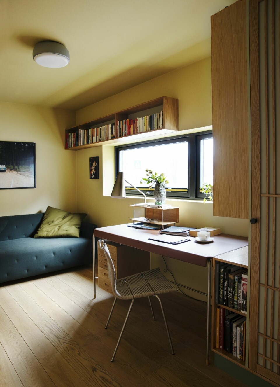 Arbeidsrommet i første etasje, som også er gjesterom, brukes av både Caroline og Tor Arne. – Jeg er utrolig fornøyd med hvordan dette rommet har blitt. Her klarer jeg å finne ro, fokus og inspirasjon. Jeg liker godt å veksle mellom å sitte på jobb i åpent landskap og kunne sitte hjemme med oppgaver som krever mer konsentrasjon, sier Caroline. Herfra har man utsikt mot Grünerhagen og Nedre Foss gård. Hyllen over vinduet er laget av kunstner og møbelsnekker Frido Evers på bestilling, mens skrivebordet er fra Carl Hansen & Søn. Taklampen er fra Northern, og gulvet er Skovin Snow eikeparkett.