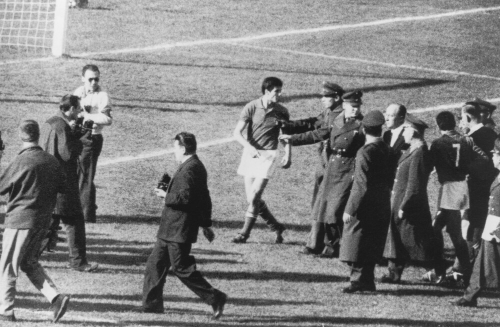 <b>POLITIESKORTE:</b> Giorgio Ferrini (skjult bak nr 7 og dommeren) geleides av banen under skandale­kampen mellom Chile og Italia i 1962, mens Sandro Salvadore (fremst) protesterer mot lag­kameratens utvisning. 