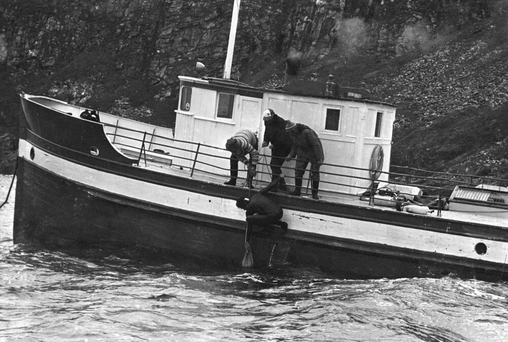 <b>SEKKEN FULL:</b> Her heises Eystein Krohn-Dale om bord dykkerbåten «Mercur II» med en sekk full av gull- og sølvmynter.