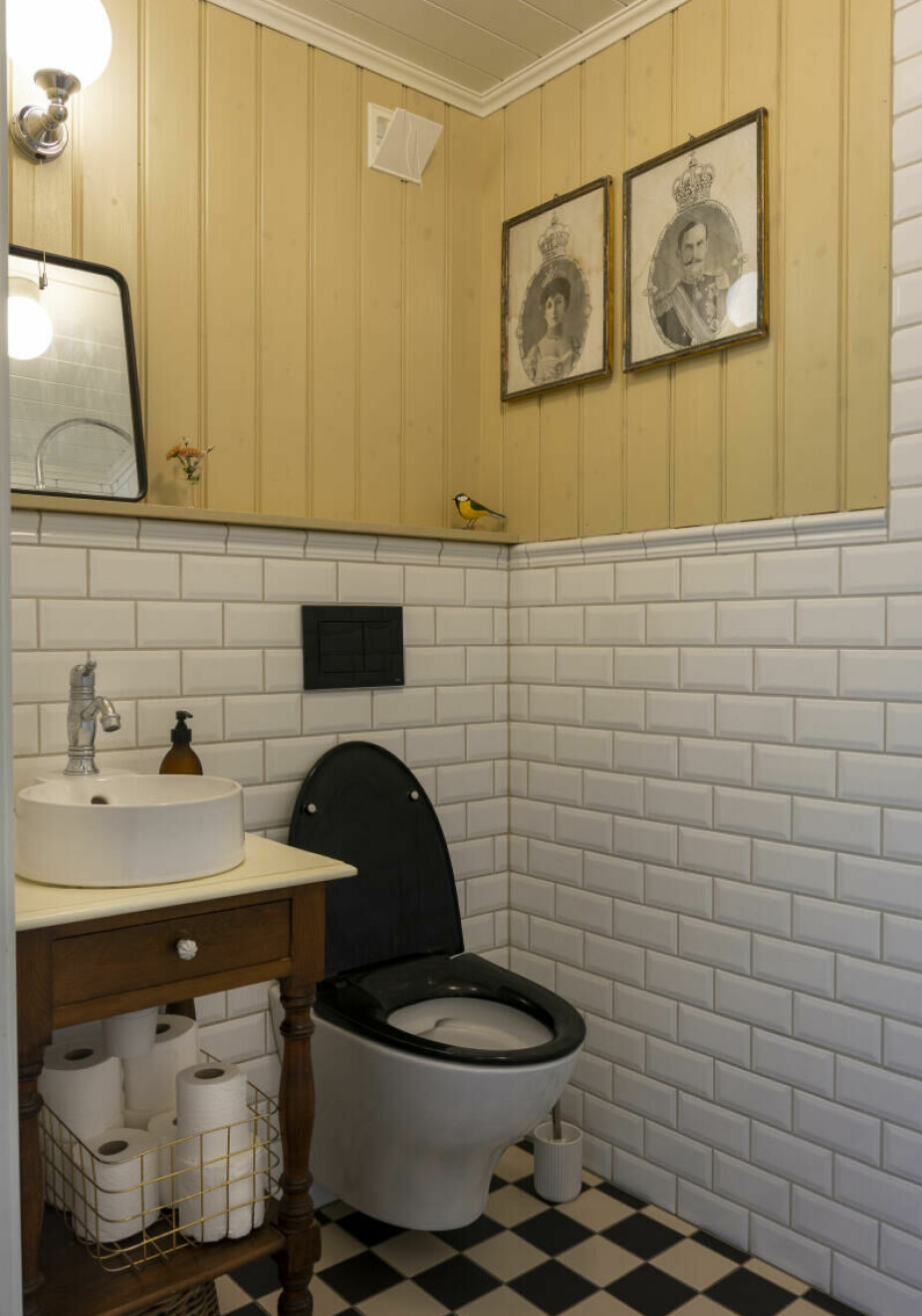 GJESTEBAD: Gjestebadet er bygget opp helt fra grunnen av, og er holdt i gammel stil ala århundreskiftet. Her er det brukt tidsriktige fliser og armaturer. Panelet er malt i Ottosons linojefärg, vetegrå. Et gammelt nattbord fungerer fint som understell til en søt liten vask. Til høyre finnes en dusj.