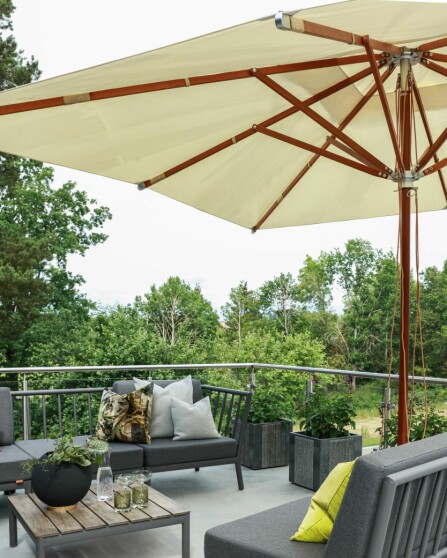 LOUNGEOMRÅDE: Loungeområdet på terrassen har utsikt over oppkjørselen og videre ut over landskapet rundt. Parasollen og møblene er fra Skagerak, putene er blant annet fra Missoni og Designers Guild.