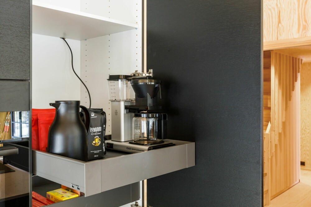 KAFFESTASJON: Kaffetrakteren er praktisk plassert i høyskapet på en hylleplate som kan trekkes ut.
