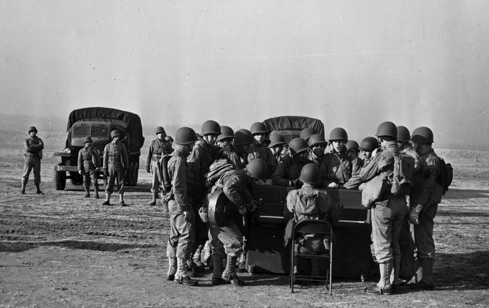 <b>JAZZET OPP STEMNINGEN:</b> Soldater samlet rundt et krigspiano ved Fort Meade i Maryland i januar 1943, før det sendes ut i tjeneste.