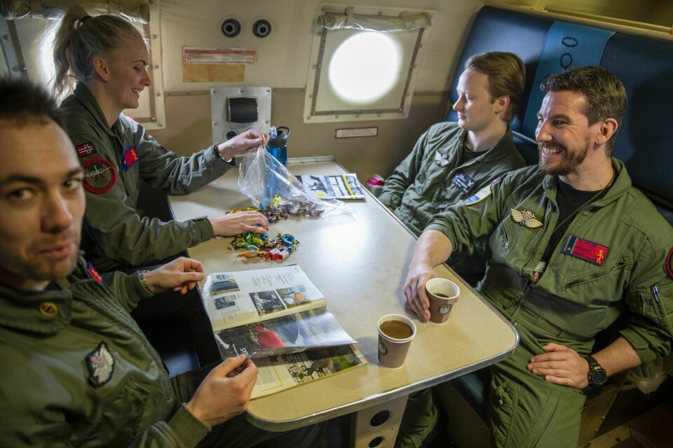 TWIST AND SHOUT: Ventetiden før avgang blir kortet ned i byssa med god lektyre og rettferdig fordeling av Twistbiter. Fra venstre pilot Thomas, systemoperatørene Mina og Adrian, og navigatør Tom.