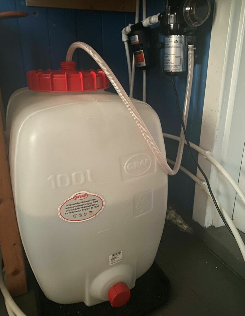 100 LITERS TANK: Ved siden av huset har Eline og Markus en bekk de henter vann fra. Da fyller de opp en hundreliters tanks som de kan bruke til å dusje.