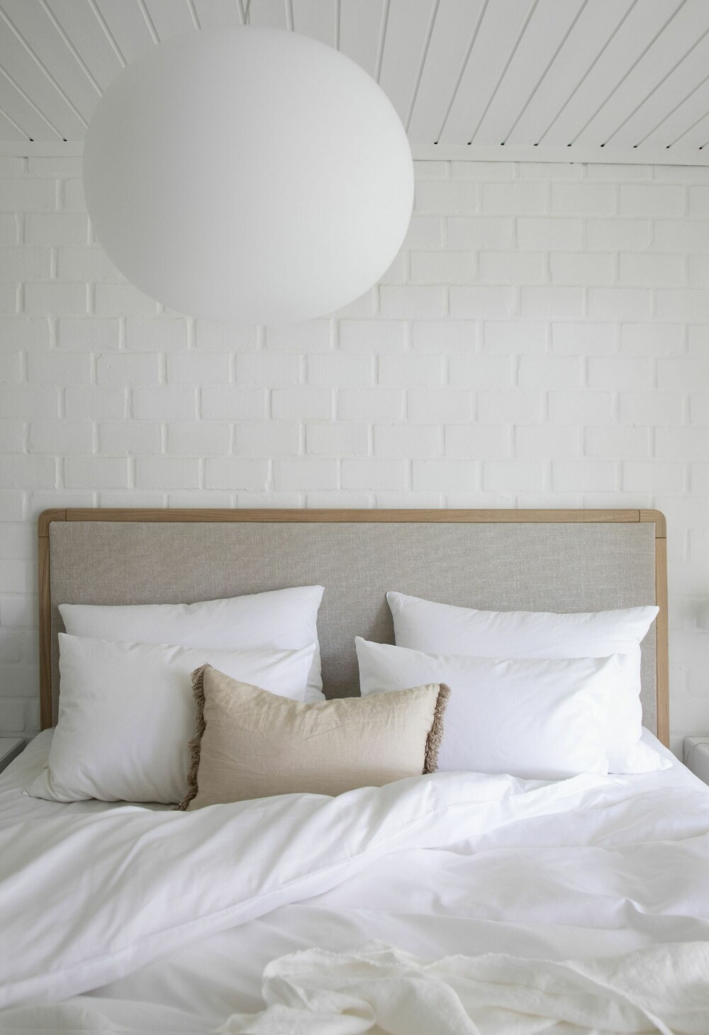 Soverommet er malt i klassisk hvit. Takpendelen Glo Ball er fra Flos og sengetøyet fra Borås Cotton.