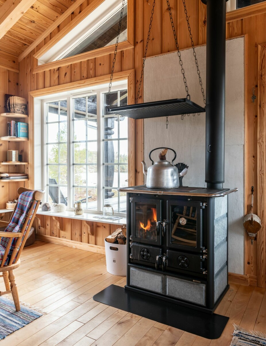 VEDKOMFYR: Den klassiske vedkomfyren fra italienske Nordica er den viktigste varmekilden i hytta. På denne kan man også varme vann, smelte snø og lage mat. Risten over kokeplatene kan benyttes som tørkestativ.