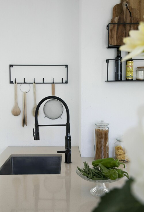 Den svarte kjøkkenkranen, fra Ikea, matches av vegghyllen og knaggrekken i serien Meert fra Fagmøbler.             