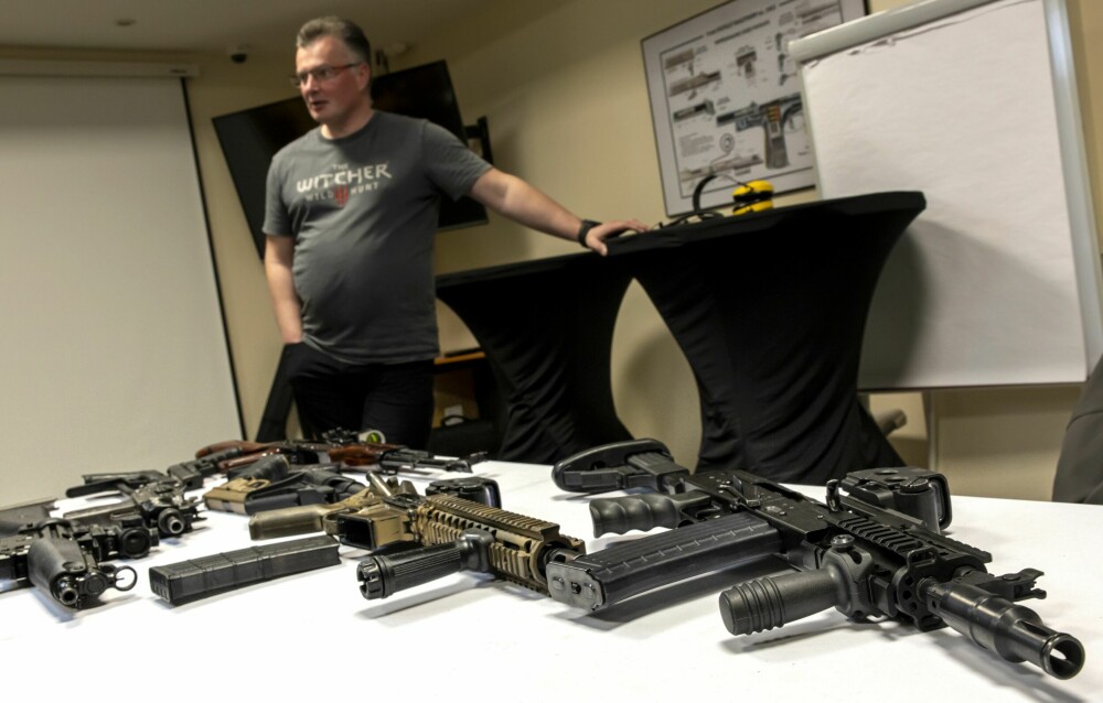 <b>PENSUMLISTEN:</b> Marek foran et bord hvor noen av våpnene ved skyteskolen ligger. Her finnes alt fra små håndvåpen til store kalasjnikover.