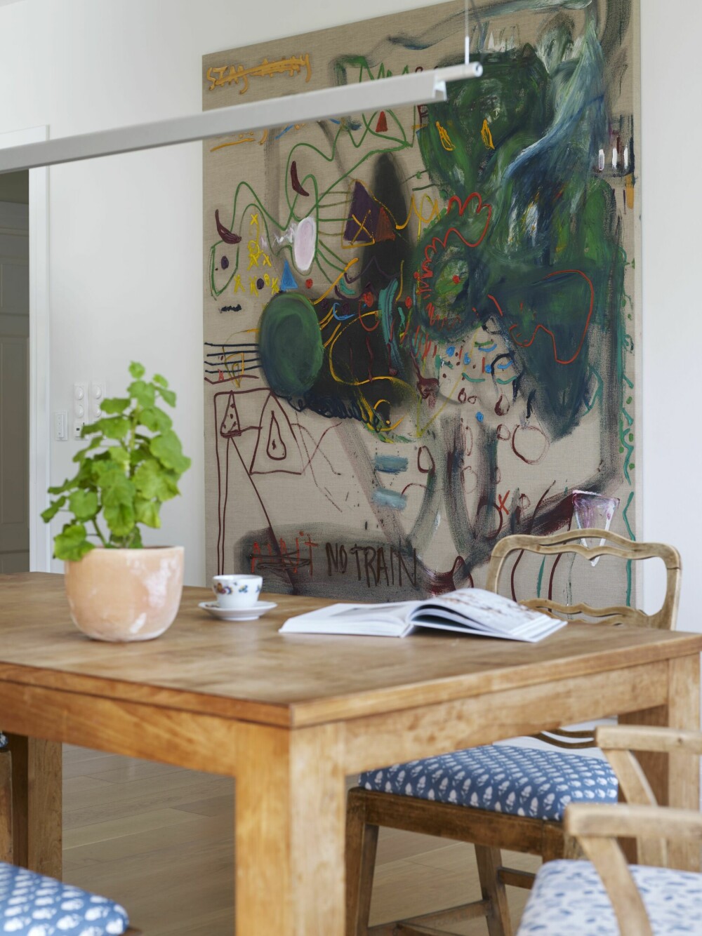 <b>KUNSTSAMLING:</b> På veggen ved spisebordet henger et maleri av den engelske, Oslo-baserte kunstneren Sebastian Helling. Lampen Compendium er designet av Daniel Rybakken for Luceplan. 