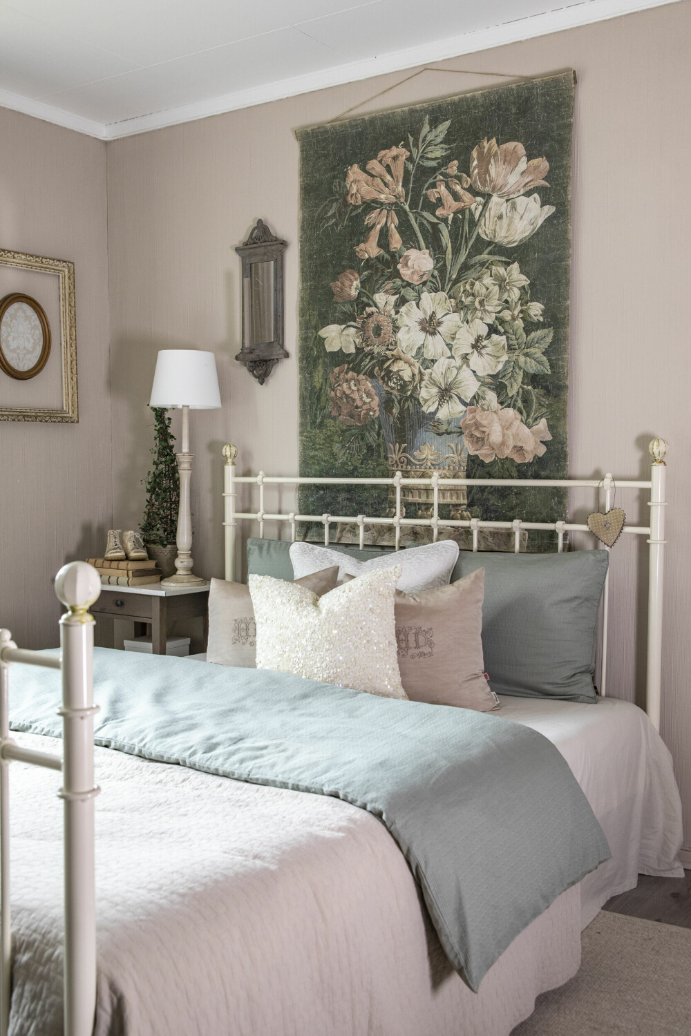 HOTELLFØLELSE: På dette romslige gjesterommet er det hotellfølelse og luksus. Fargene går i duse rosatoner og bak senga har hun hengt et stort blomstermaleri.